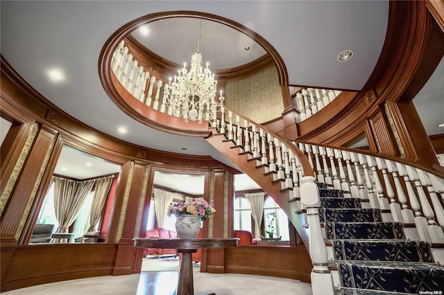 staircase with a towering ceiling and ornamental molding