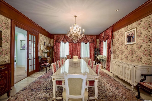 dining space featuring french doors, crown molding, and a chandelier