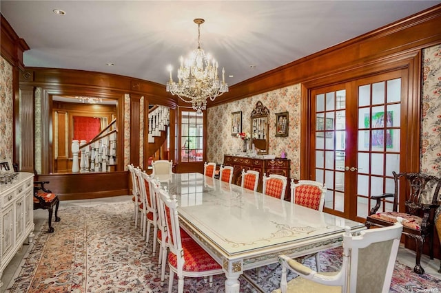 dining area featuring plenty of natural light, an inviting chandelier, ornamental molding, and french doors