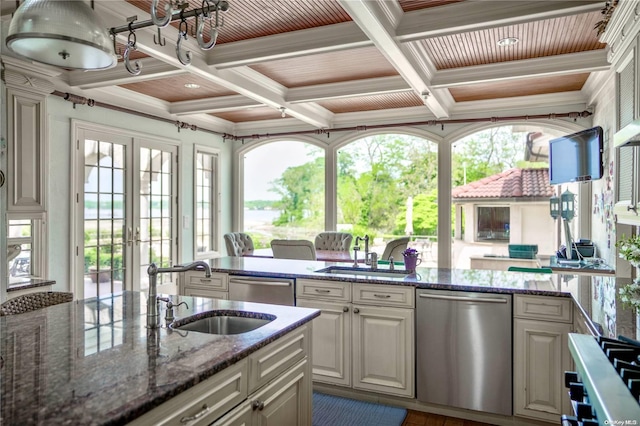 kitchen featuring stainless steel dishwasher, sink, a wealth of natural light, and coffered ceiling