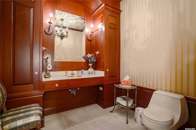 bathroom with toilet, sink, tile patterned flooring, and a notable chandelier