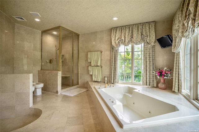 bathroom with a textured ceiling, tile walls, independent shower and bath, a bidet, and tile patterned flooring