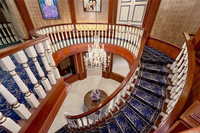 stairs featuring a chandelier