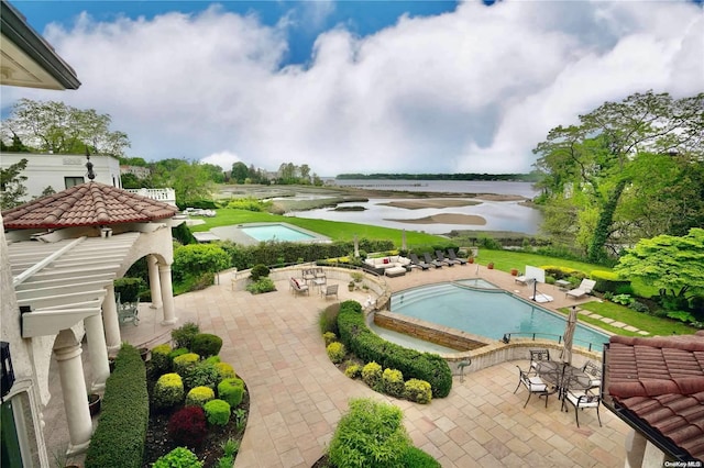 view of pool with a water view and a patio area