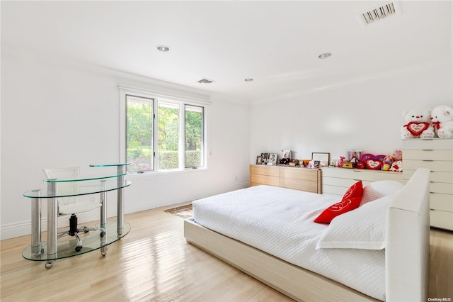 bedroom with wood-type flooring and ornamental molding