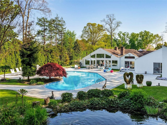 view of pool featuring a patio area and a water view