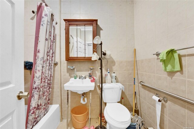 full bathroom featuring shower / bath combo, toilet, tile walls, and sink