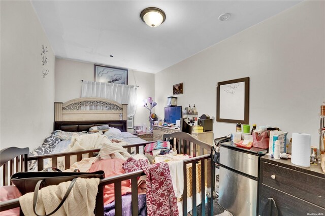 bedroom featuring stainless steel refrigerator