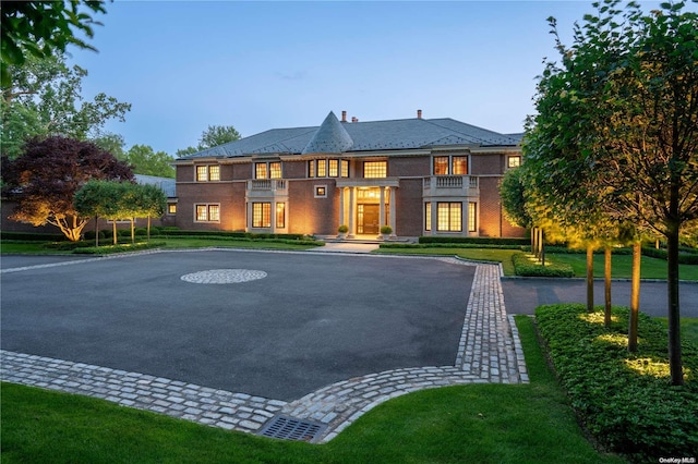 view of front of property with a lawn and a balcony