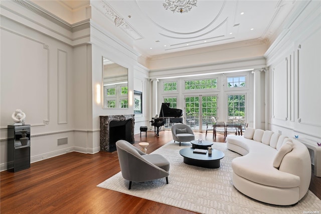 living room featuring hardwood / wood-style floors, a towering ceiling, and ornamental molding