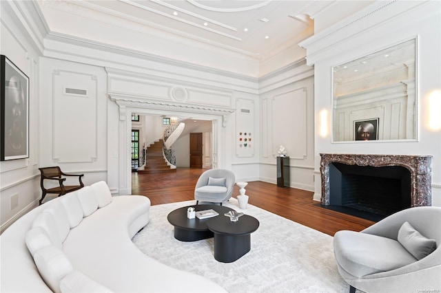 living room with crown molding, dark hardwood / wood-style flooring, and a fireplace