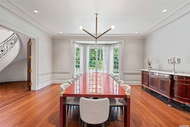 dining area featuring a notable chandelier, light wood-type flooring, and ornamental molding