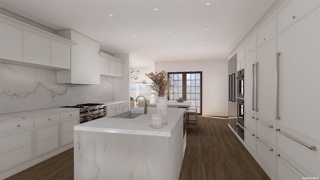 kitchen with dark wood-type flooring, sink, an island with sink, tasteful backsplash, and stainless steel appliances