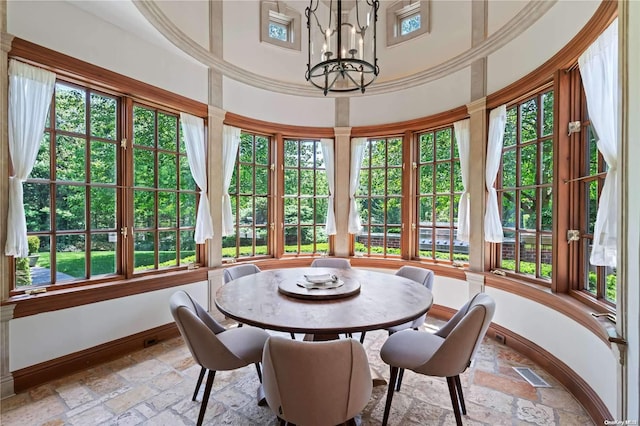 sunroom / solarium featuring a chandelier, french doors, and plenty of natural light