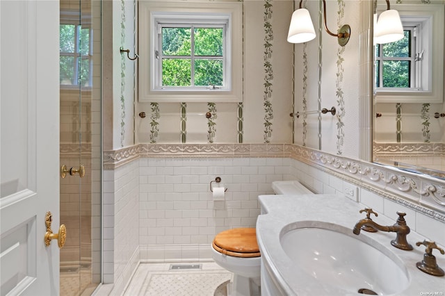 bathroom with toilet, sink, walk in shower, and tile walls