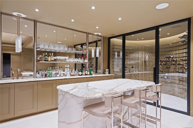 bar featuring light stone countertops, sink, and hanging light fixtures