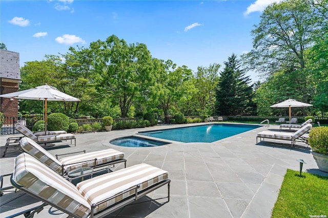 view of swimming pool featuring an in ground hot tub and a patio