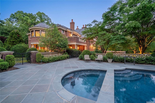 view of pool featuring a patio area and an in ground hot tub