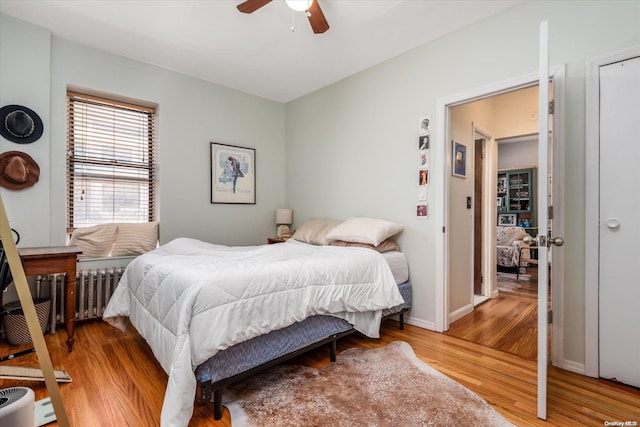 bedroom with radiator, hardwood / wood-style flooring, and ceiling fan