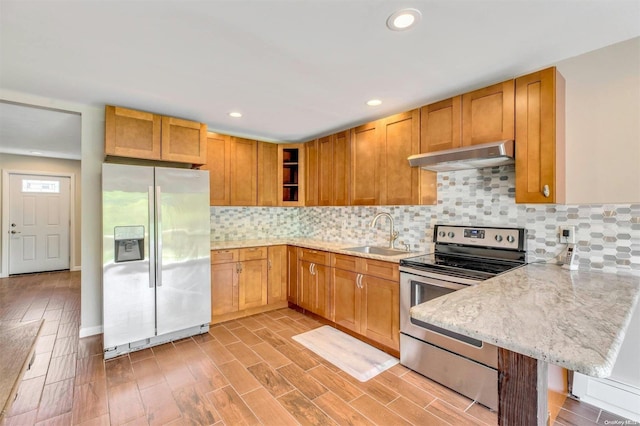 kitchen featuring a breakfast bar, stainless steel electric stove, sink, refrigerator with ice dispenser, and light hardwood / wood-style floors