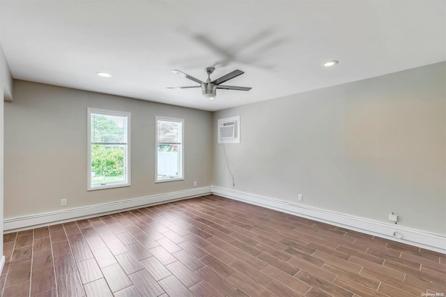 empty room featuring hardwood / wood-style floors, ceiling fan, a wall unit AC, and a baseboard heating unit