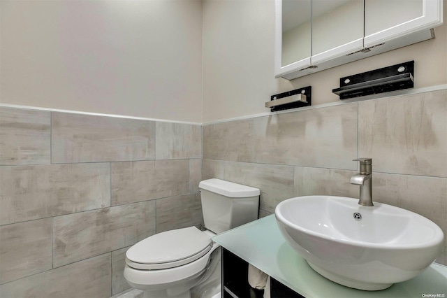 bathroom featuring sink, tile walls, and toilet