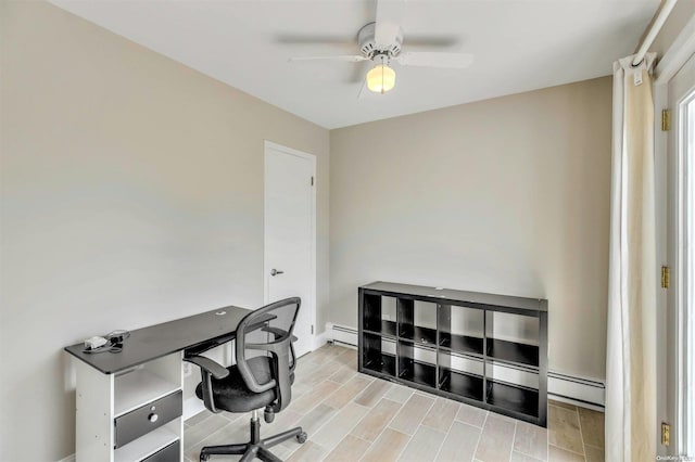 home office with ceiling fan, light wood-type flooring, and a baseboard heating unit