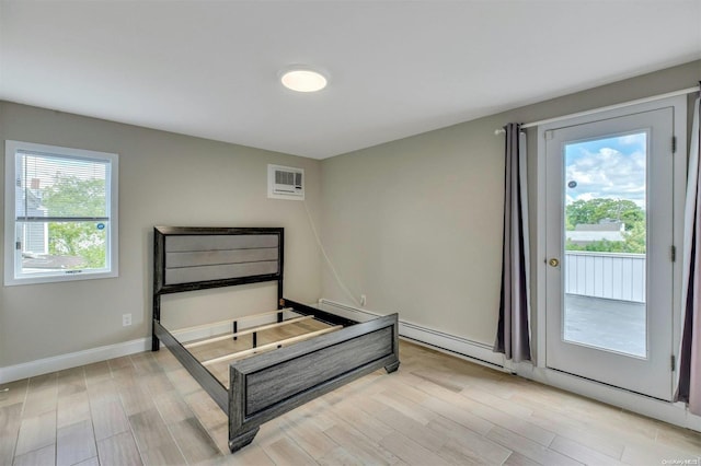 bedroom with light hardwood / wood-style floors, an AC wall unit, a baseboard heating unit, and multiple windows