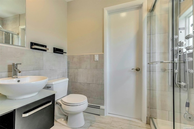 bathroom featuring a baseboard radiator, toilet, vanity, a shower with shower door, and tile walls