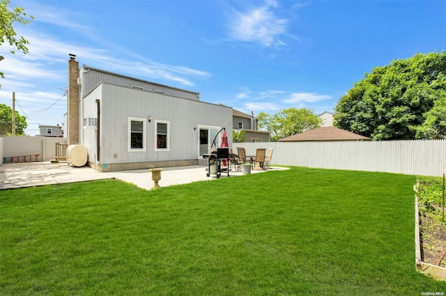 rear view of house with a lawn and a patio