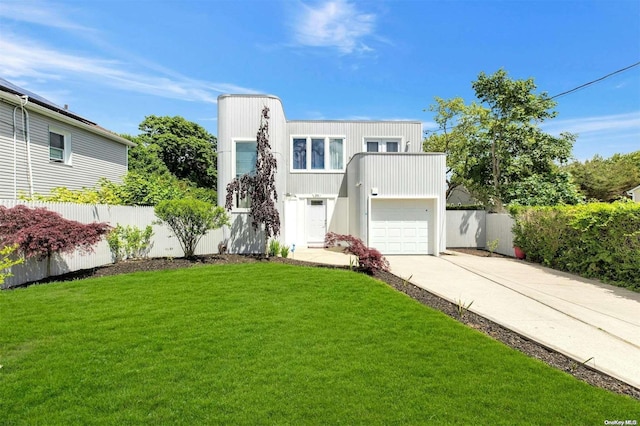 contemporary house featuring a garage and a front lawn