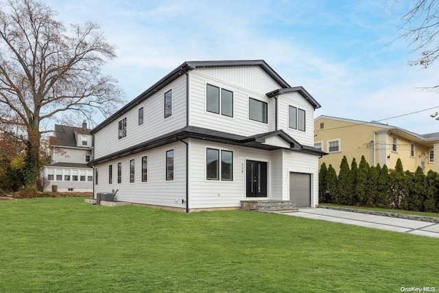 view of front facade featuring cooling unit, a garage, and a front lawn