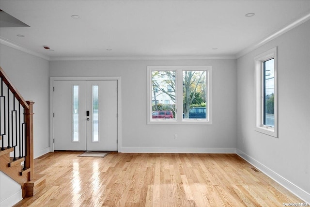 foyer with crown molding and light hardwood / wood-style flooring