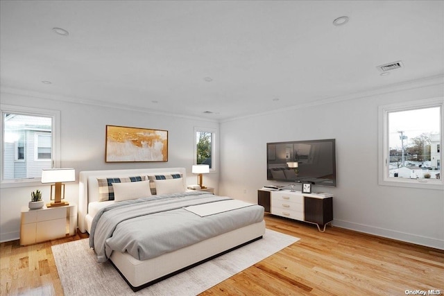 bedroom with light hardwood / wood-style flooring and ornamental molding