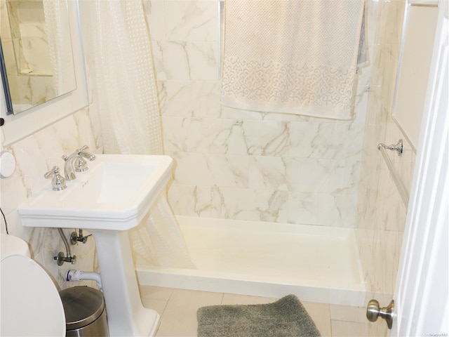 bathroom with tile patterned flooring, curtained shower, toilet, and tile walls