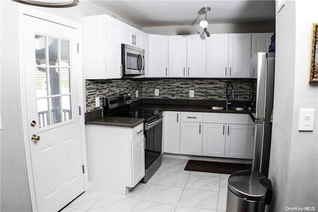 kitchen featuring appliances with stainless steel finishes, backsplash, white cabinetry, and sink