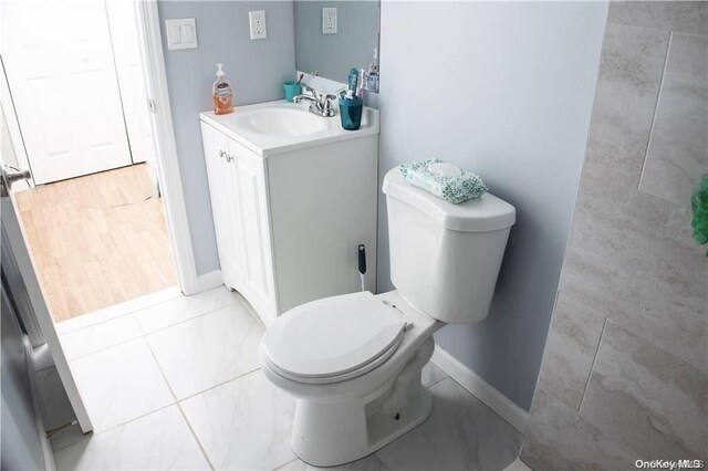 bathroom featuring tile patterned flooring, vanity, and toilet