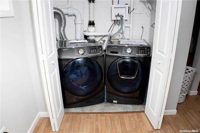 laundry room featuring light hardwood / wood-style flooring and washer and dryer