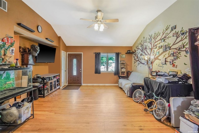 living room with ceiling fan, light wood-type flooring, and vaulted ceiling