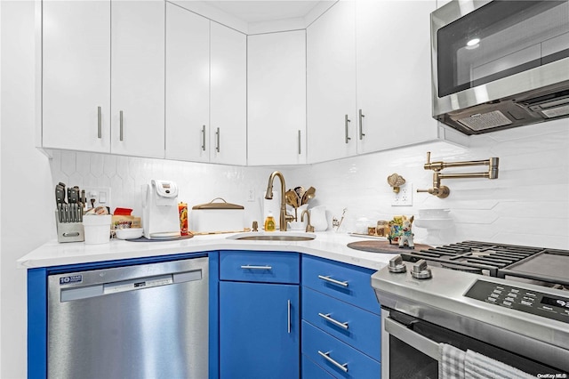 kitchen with white cabinets, stainless steel appliances, blue cabinets, and sink