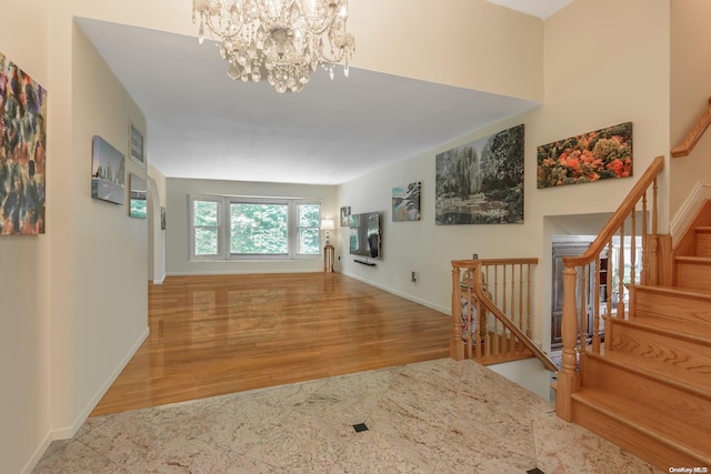 corridor featuring an inviting chandelier and light hardwood / wood-style flooring