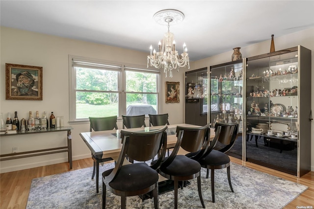 dining space with a notable chandelier and light wood-type flooring