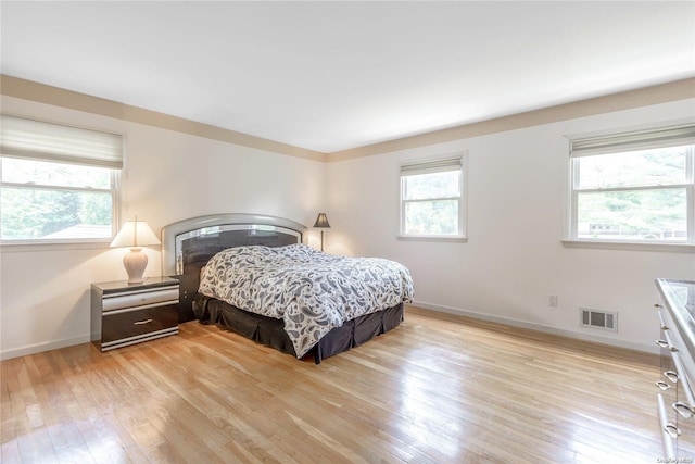 bedroom featuring multiple windows and light hardwood / wood-style flooring