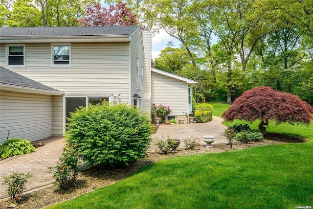 view of side of property featuring a yard and a patio area