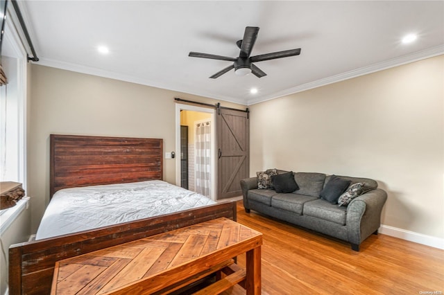 bedroom featuring a barn door, ceiling fan, ornamental molding, and light wood-type flooring