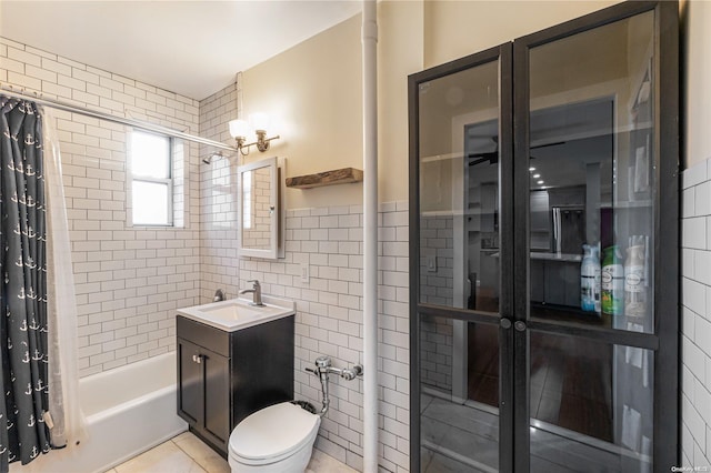 full bathroom with vanity, tile patterned flooring, shower / bath combo, and tile walls