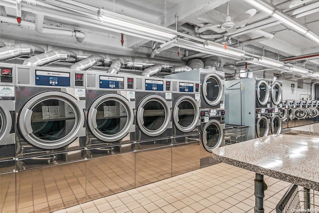 laundry room with stacked washer / dryer, tile patterned flooring, and washing machine and dryer