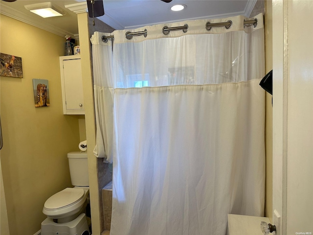 bathroom with a shower with shower curtain, toilet, and crown molding