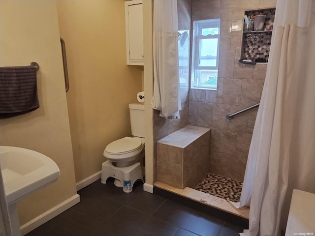 bathroom with tile patterned flooring, toilet, curtained shower, and sink