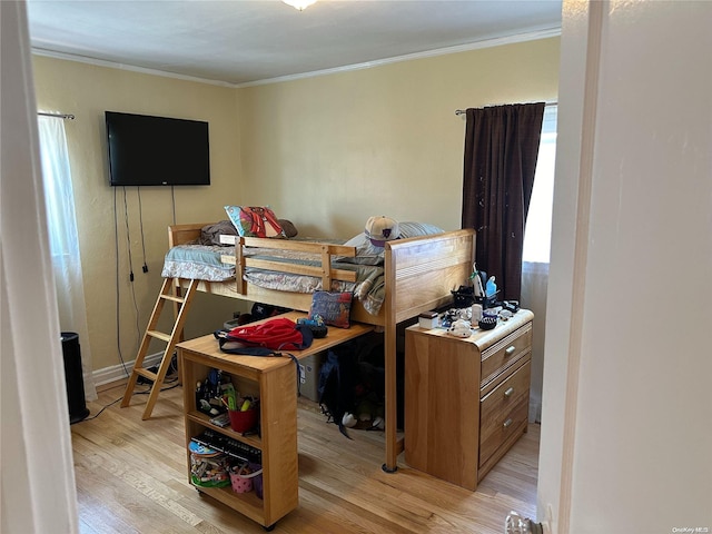 bedroom with light hardwood / wood-style floors and ornamental molding